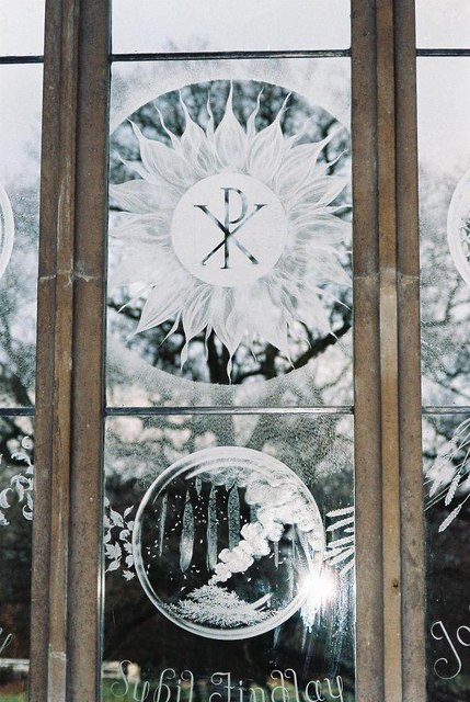 Fine engraved glass with a radiant Christian monogram and natural forms